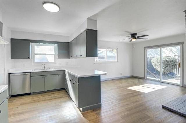 kitchen with dishwasher, light hardwood / wood-style floors, sink, kitchen peninsula, and ceiling fan