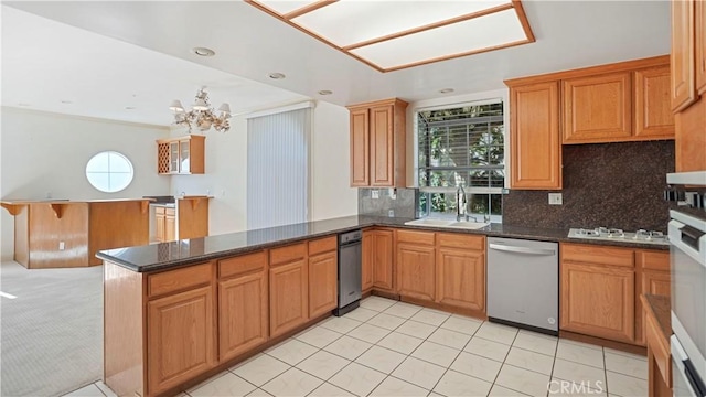 kitchen featuring sink, appliances with stainless steel finishes, tasteful backsplash, a notable chandelier, and kitchen peninsula