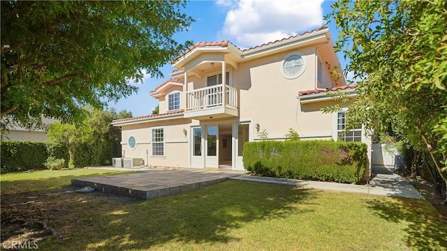 rear view of house featuring a yard, central air condition unit, and a balcony