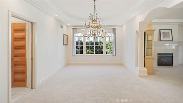 unfurnished dining area with a tiled fireplace, crown molding, and light carpet