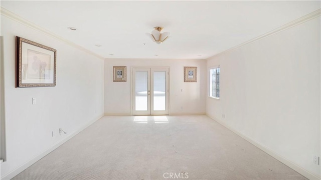 carpeted spare room featuring french doors and ornamental molding