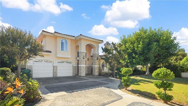 mediterranean / spanish-style house with a garage and a front lawn