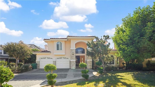 mediterranean / spanish-style home featuring a front yard and a garage