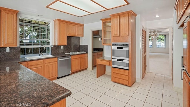 kitchen with decorative backsplash, light tile patterned floors, stainless steel appliances, and sink