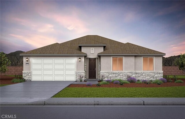 view of front of property with a garage and a lawn