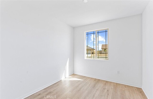 unfurnished room featuring light wood-style flooring and baseboards