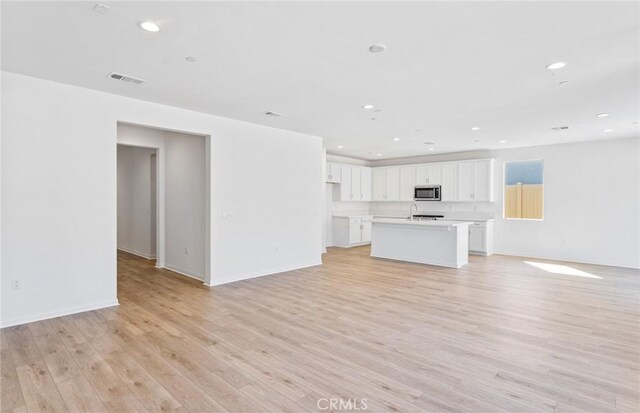 unfurnished living room featuring light wood-style flooring, visible vents, and recessed lighting