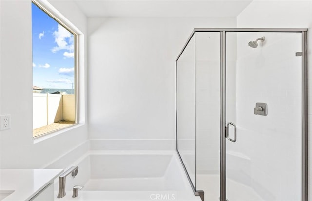 bathroom with a shower stall, vanity, and a bath