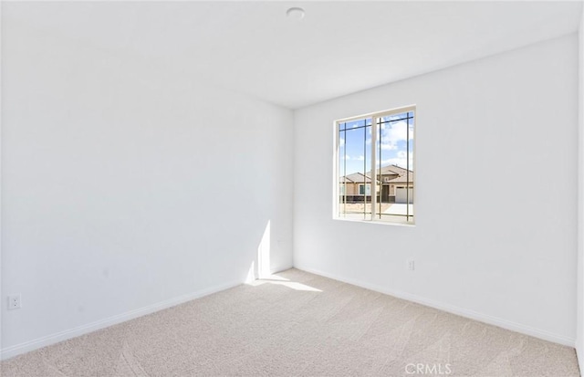 spare room with carpet floors and baseboards