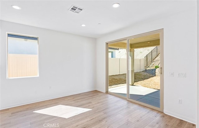 unfurnished room featuring baseboards, visible vents, wood finished floors, and recessed lighting