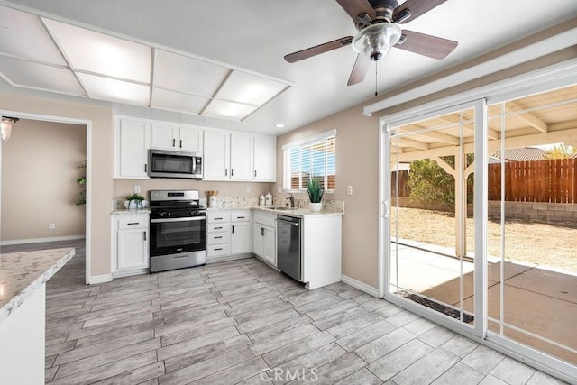 kitchen featuring ceiling fan, sink, white cabinetry, and stainless steel appliances