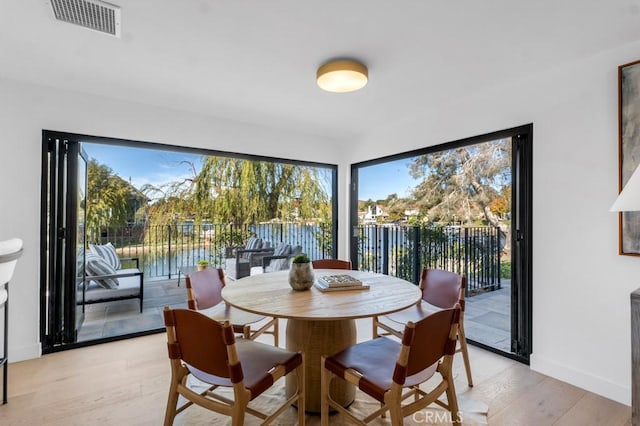 dining room with a water view and light wood-type flooring