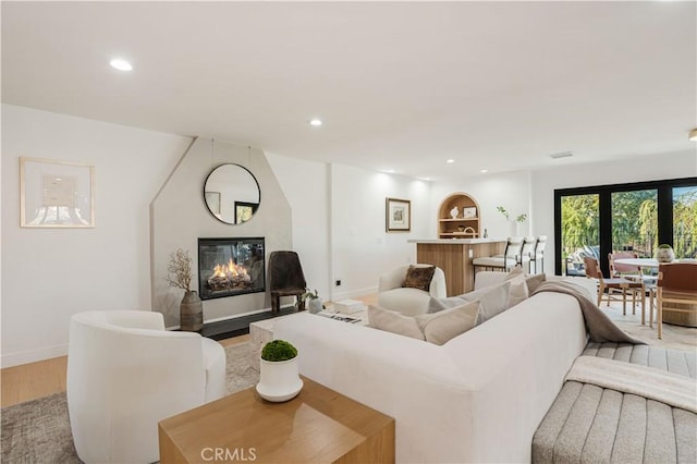 living room with a large fireplace and light hardwood / wood-style flooring