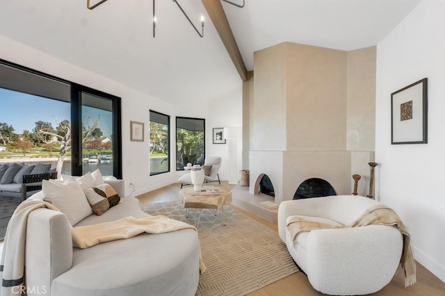 living room featuring a fireplace, beamed ceiling, and light wood-type flooring