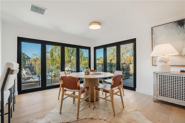 dining area featuring french doors and light hardwood / wood-style flooring