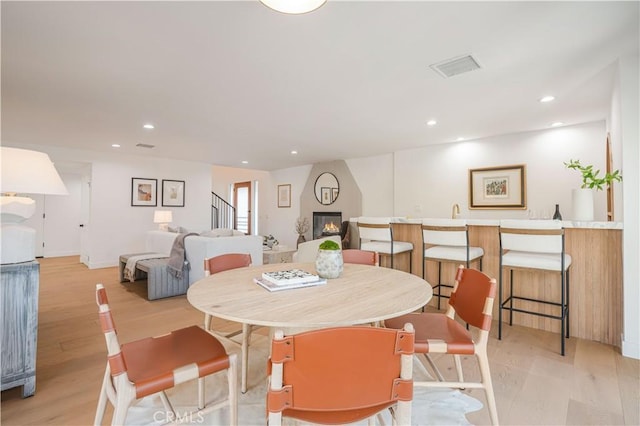 dining area with a fireplace and light hardwood / wood-style flooring