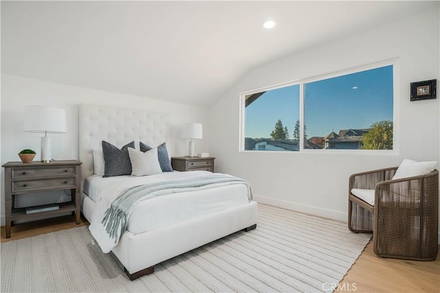 bedroom featuring light wood-type flooring and lofted ceiling