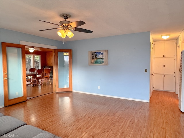 unfurnished living room with french doors, light hardwood / wood-style flooring, and ceiling fan