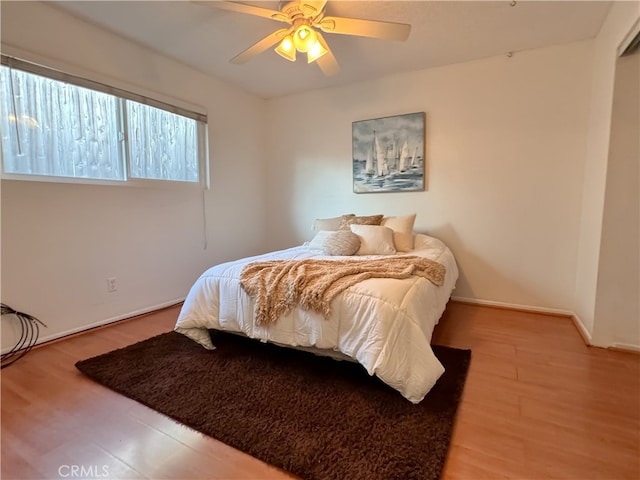 bedroom with hardwood / wood-style floors and ceiling fan