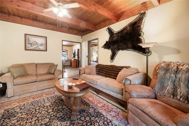 living room with beamed ceiling, ceiling fan, and wood ceiling