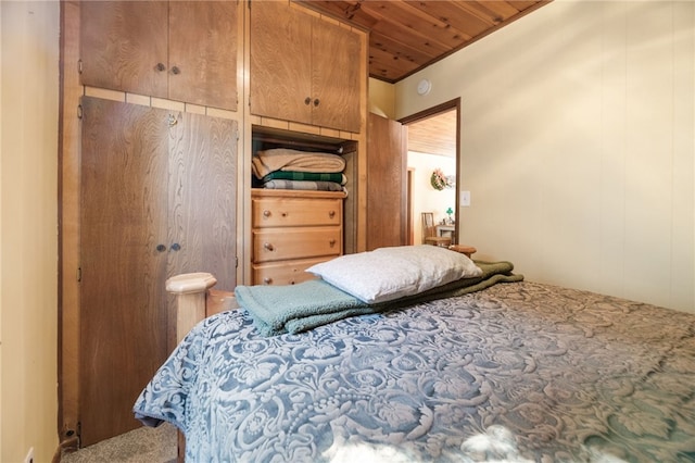 bedroom featuring wooden walls, carpet floors, and wooden ceiling