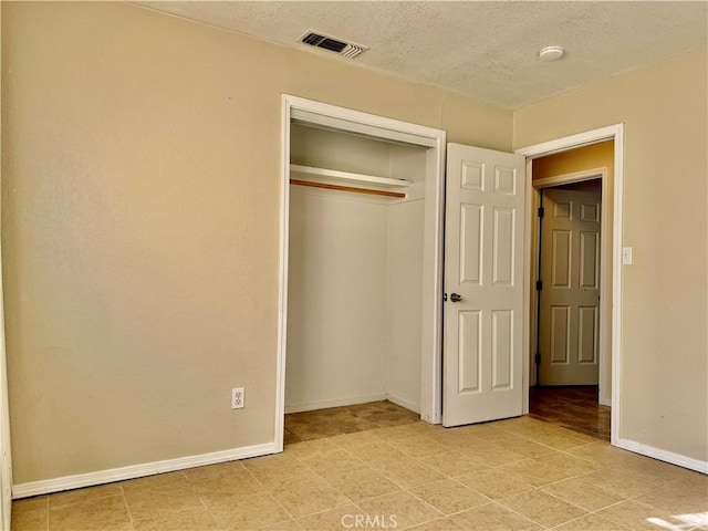 unfurnished bedroom featuring a textured ceiling and a closet