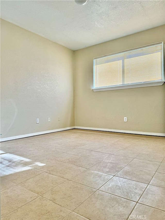 unfurnished room featuring light tile patterned floors and a textured ceiling