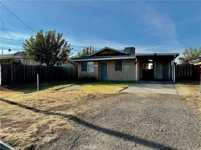 view of front facade featuring central air condition unit, a front lawn, and a carport