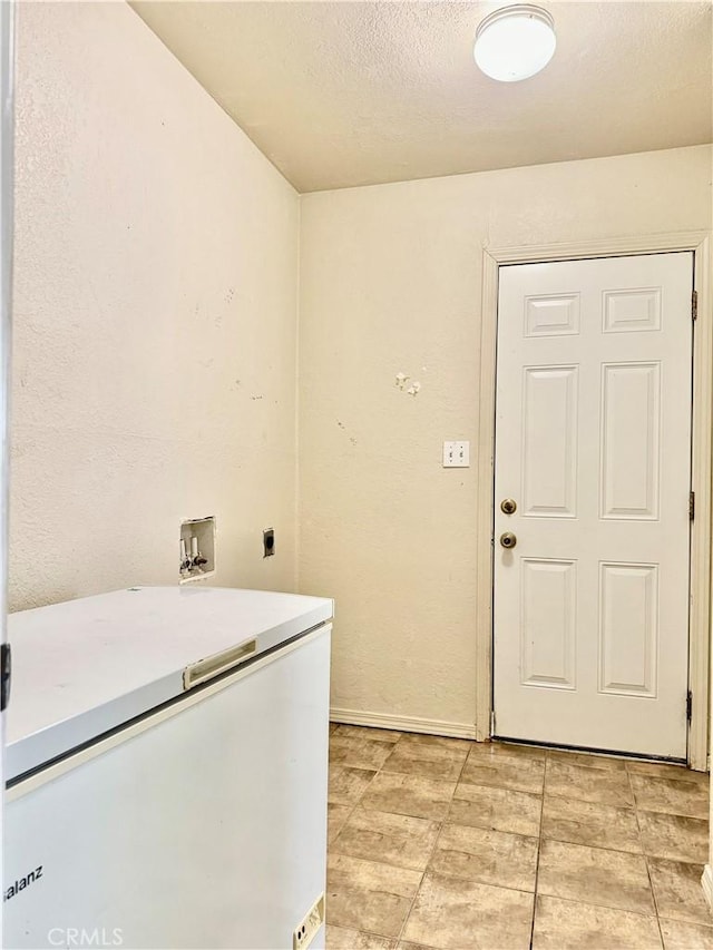 laundry area with electric dryer hookup, washer hookup, and a textured ceiling