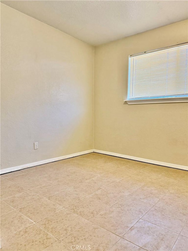 empty room featuring tile patterned flooring and a textured ceiling