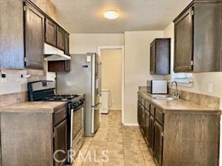 kitchen featuring dark brown cabinetry, stainless steel range with gas cooktop, sink, and light tile patterned floors