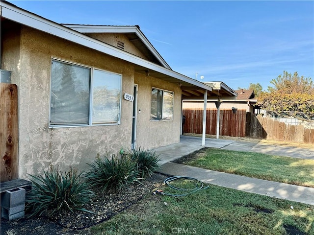 view of side of property with a lawn and a patio area