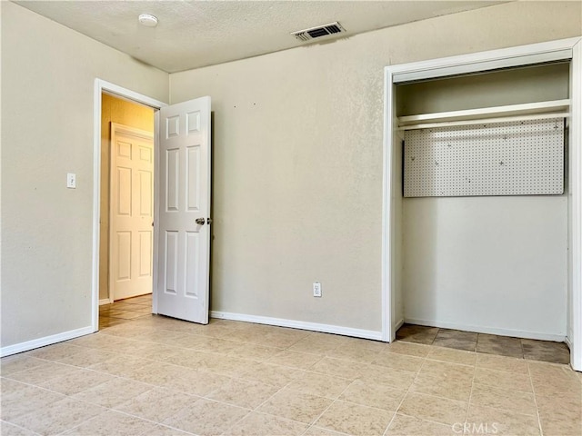 unfurnished bedroom with light tile patterned floors and a textured ceiling