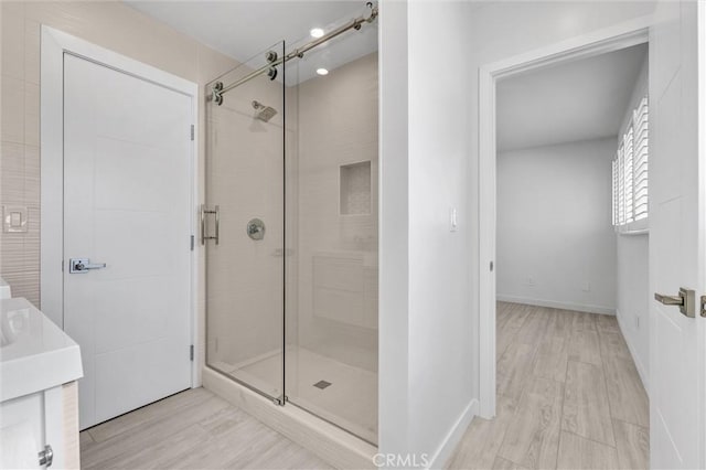 bathroom with wood-type flooring, vanity, and walk in shower