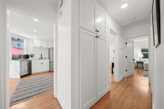 hall featuring light hardwood / wood-style floors and sink