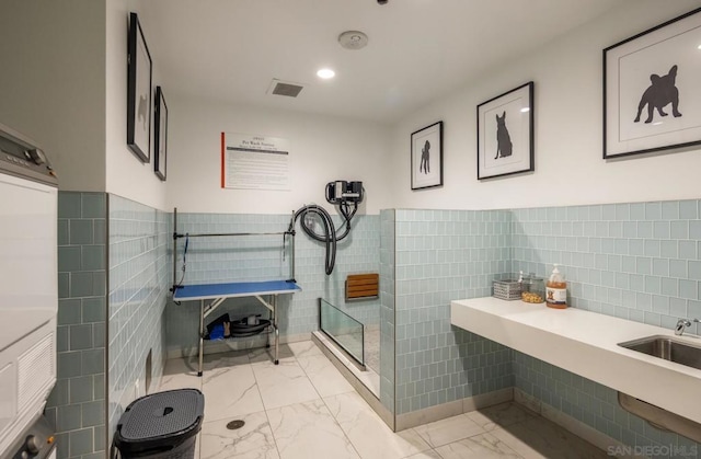 bathroom with sink and tile walls