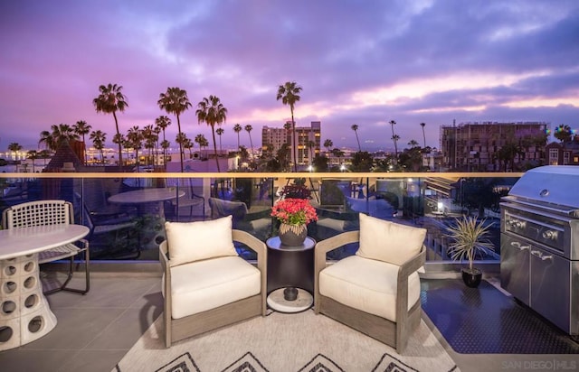 patio terrace at dusk featuring a balcony