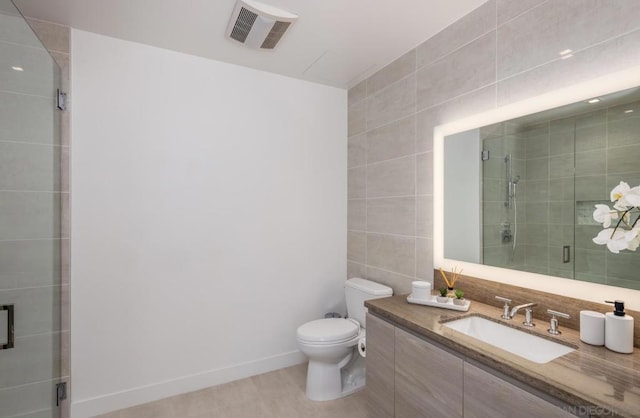 bathroom with a shower with shower door, tile walls, toilet, and vanity