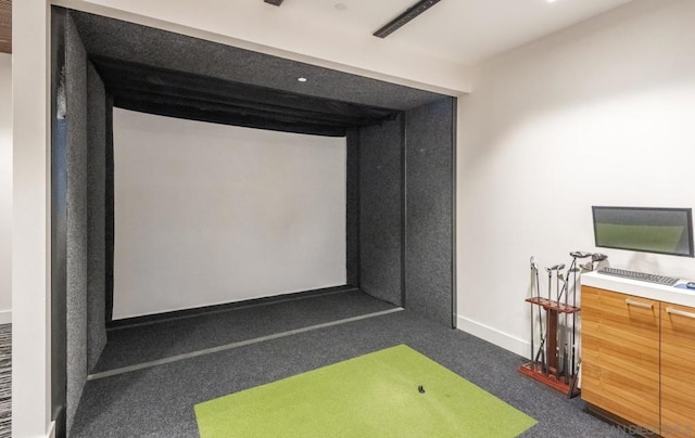 recreation room with dark colored carpet and golf simulator