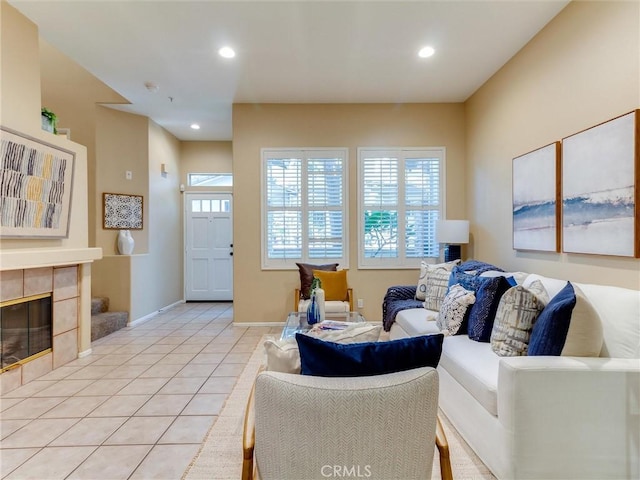 tiled living room featuring a healthy amount of sunlight and a tiled fireplace