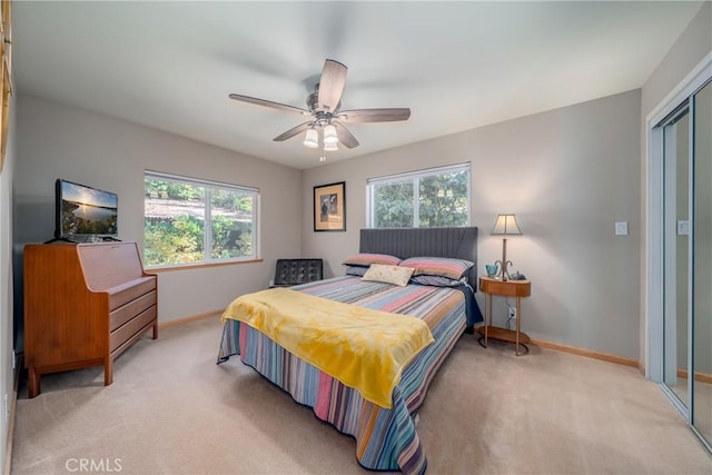 carpeted bedroom with a closet, multiple windows, and ceiling fan