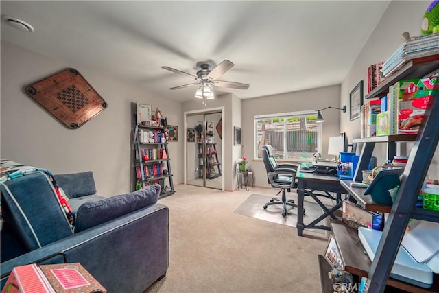 carpeted home office featuring ceiling fan