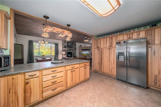 kitchen featuring a fireplace, decorative light fixtures, and stainless steel appliances