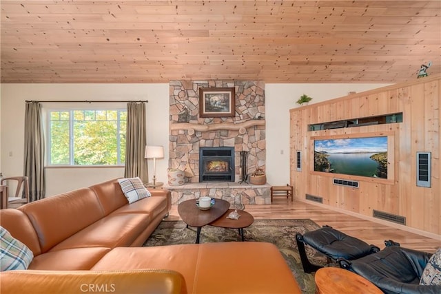 living room with vaulted ceiling, wooden walls, wooden ceiling, a fireplace, and hardwood / wood-style floors