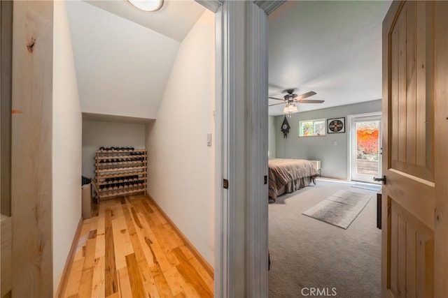 hall with vaulted ceiling and light wood-type flooring