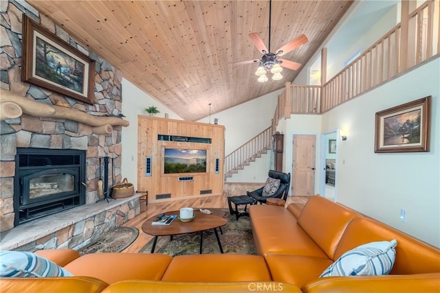 living room featuring a stone fireplace, ceiling fan, high vaulted ceiling, and wood ceiling