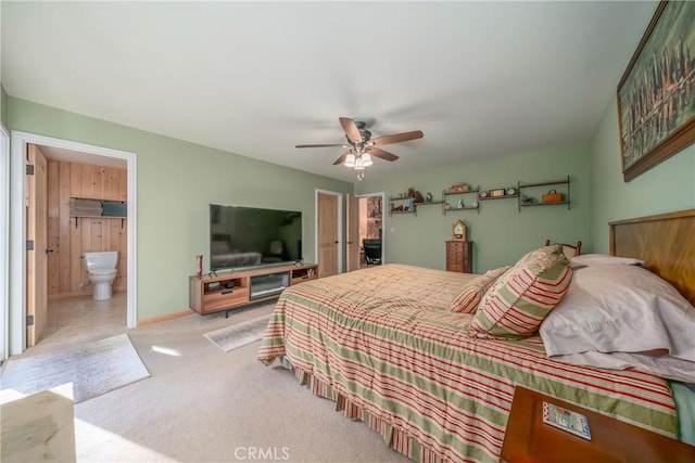 bedroom with light colored carpet, ensuite bath, and ceiling fan