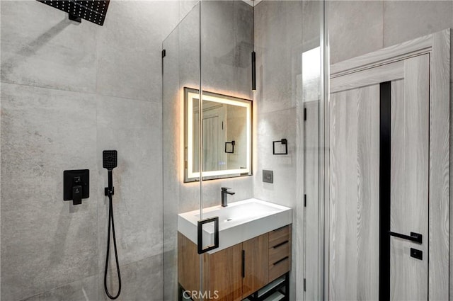 bathroom featuring tiled shower and vanity