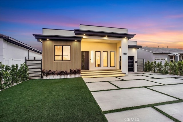 contemporary house with a patio and a lawn