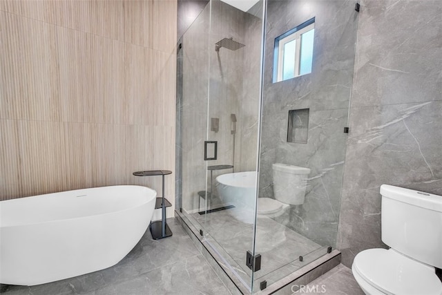 bathroom with tile walls, toilet, and separate shower and tub